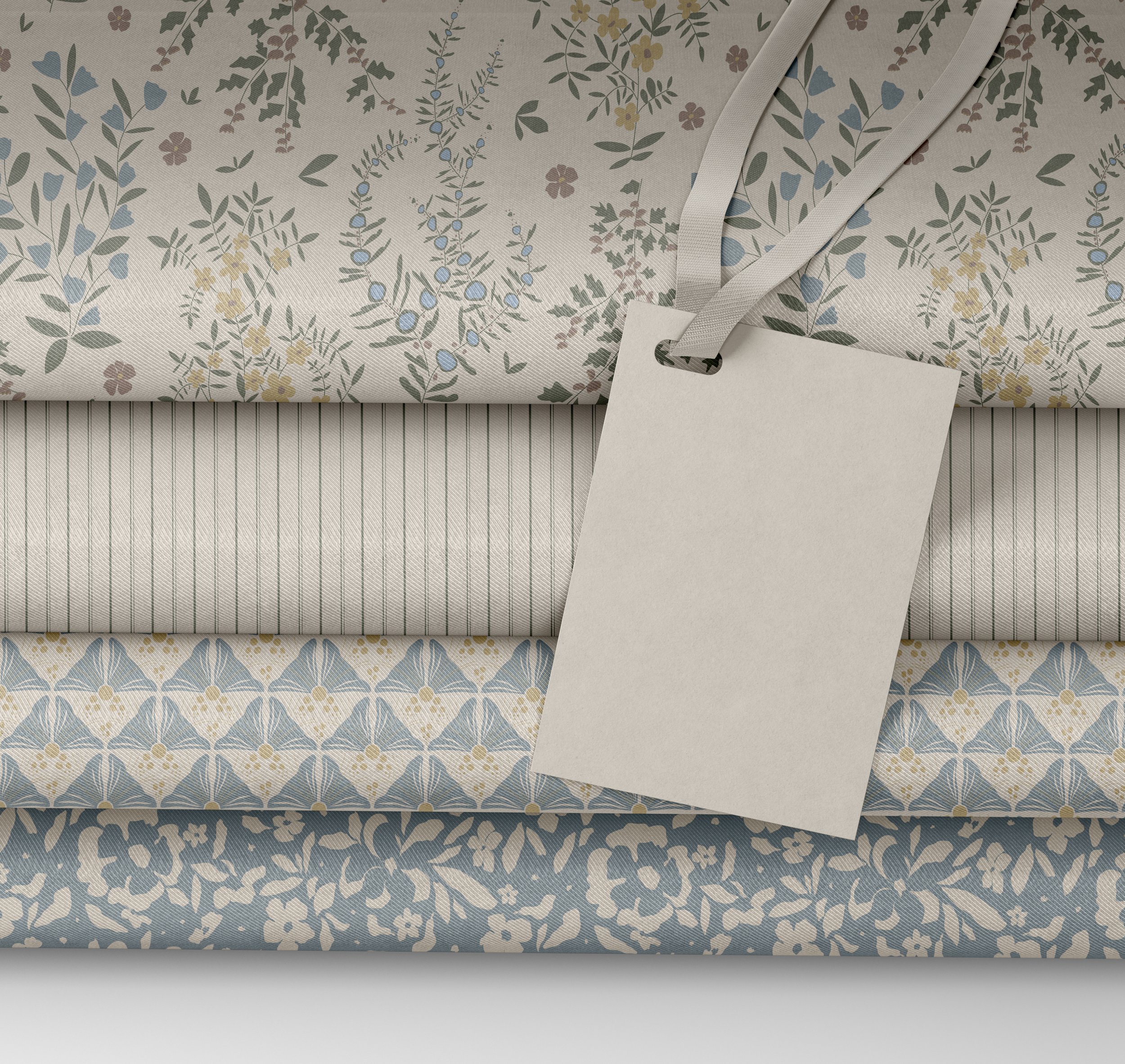 Close-up of a fabric with a floral pattern in pastel colors, layered with plain fabric and a blank tag attached.