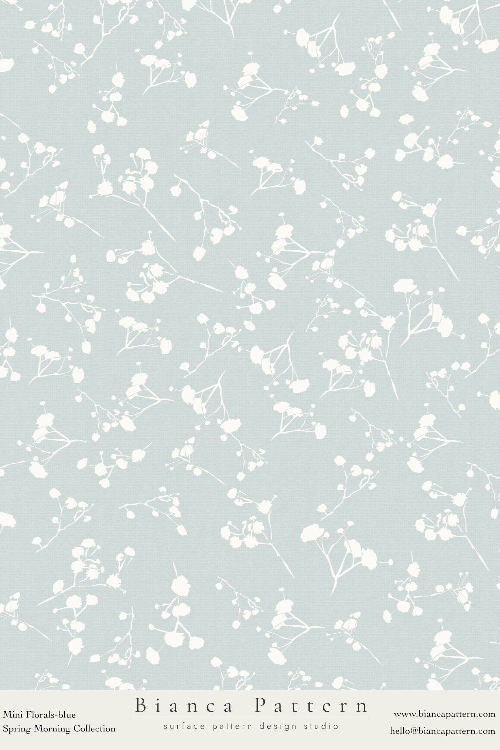 Light blue wallpaper with white floral pattern of small flowers and branches.