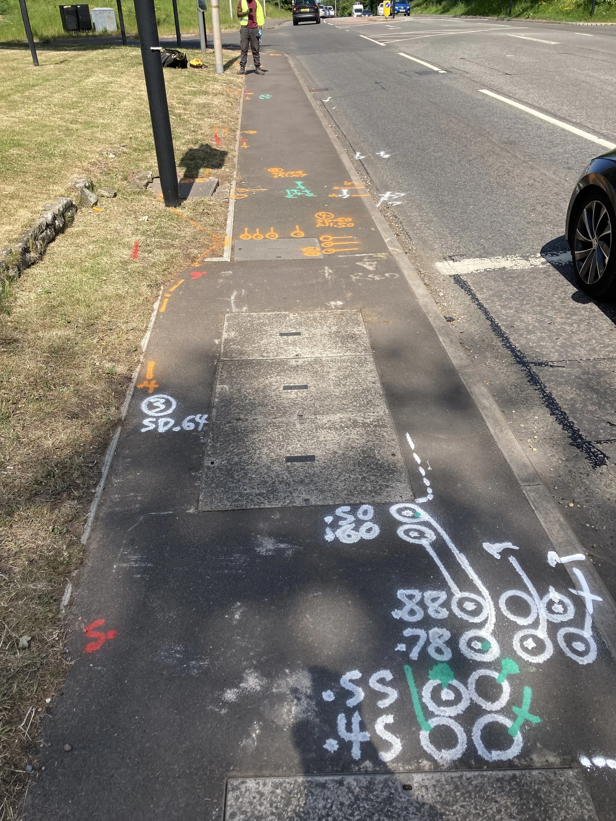 Colorful chalk markings on a sidewalk showing a diagram of a bicycle and related measurements, with some numbered annotations and directional arrows.