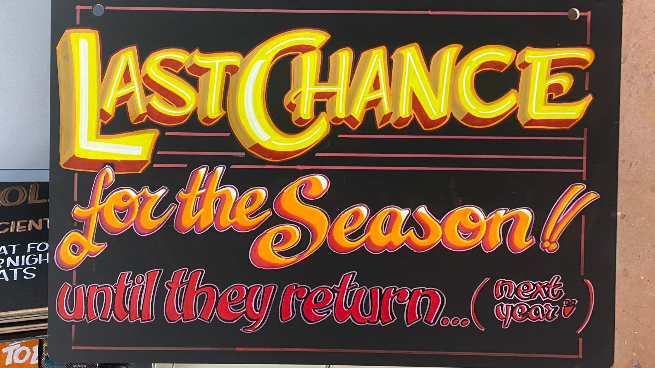 A colorful end-cap sign on a black background that reads: 'LAST CHANCE for the Season! until they return... (next year)'