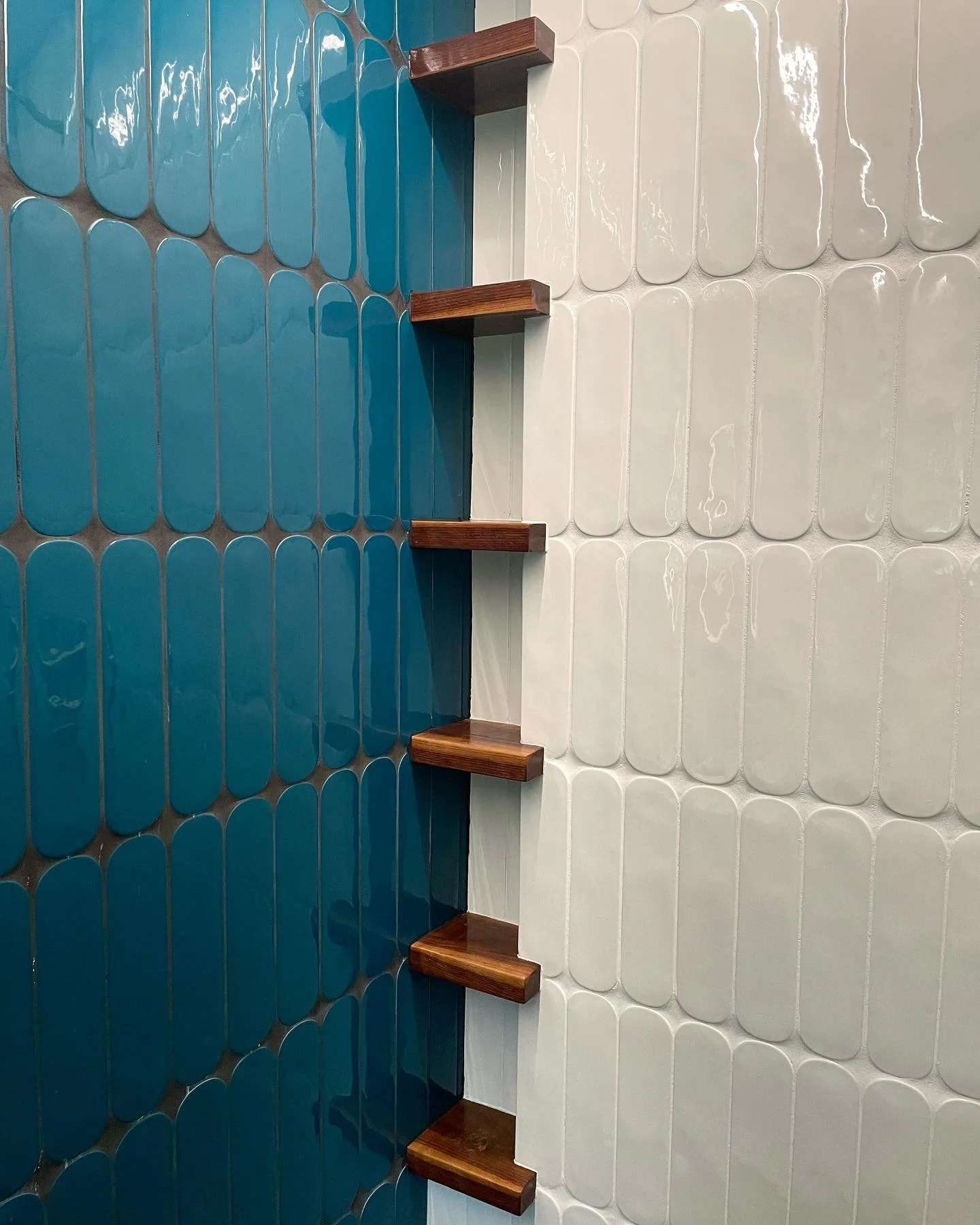Interior wall with white and blue ceramic tiles and four wooden shelves. Heartwood Renovations. West Hartford, CT