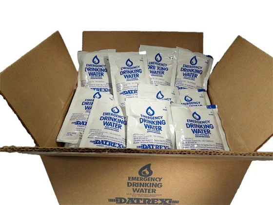 A cardboard box filled with multiple packages of emergency drinking water pouches.