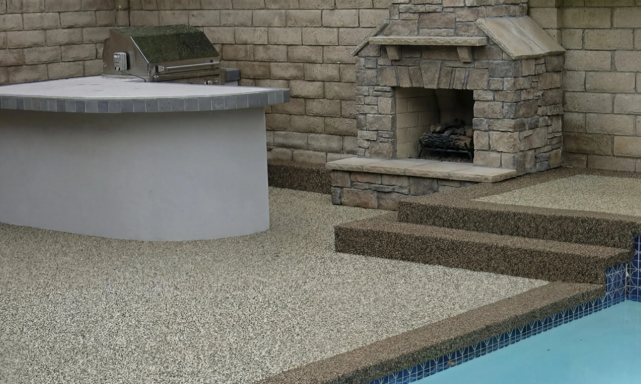 A backyard with a stone fireplace, concrete steps, and a swimming pool with blue mosaic tiles.