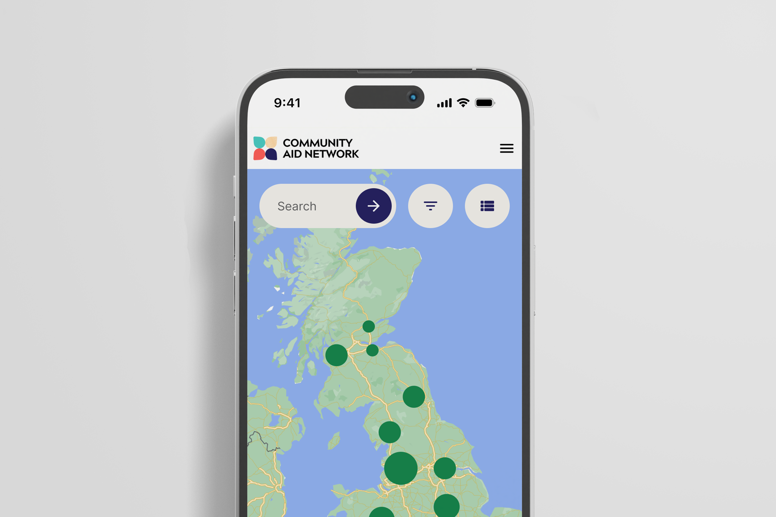 Mobile phone displaying a map of the UK with green markers, showing an app called Community Aid Network with search bar and filter icons.