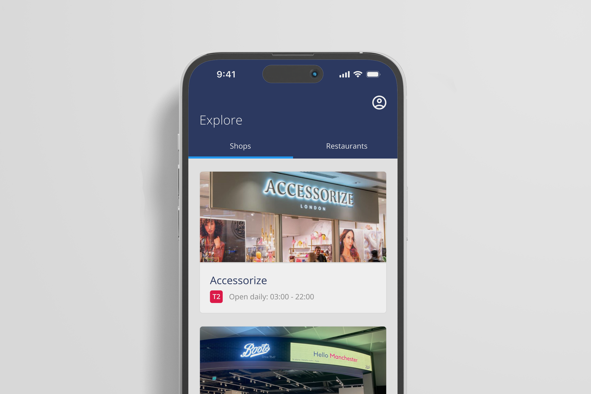 Mobile app screen showing Explore section with shops and restaurants, featuring Accessorize London store, its opening hours, and partial view of Boots store sign in Manchester.