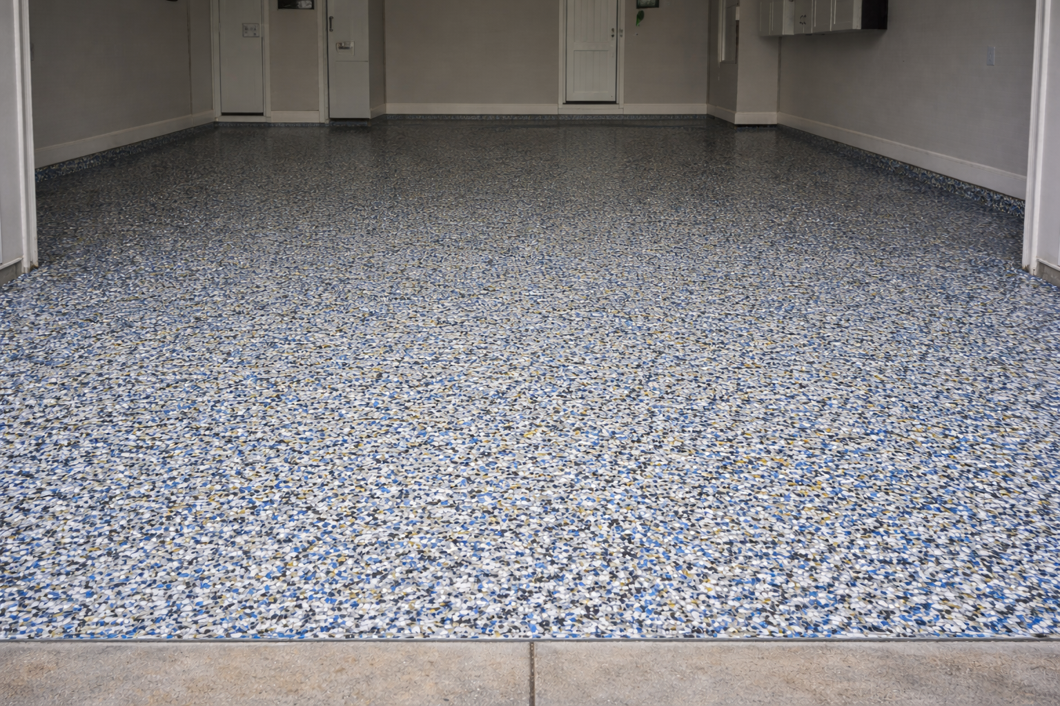 Empty room with terrazzo flooring, light-colored walls, and metallic cabinets and appliances.