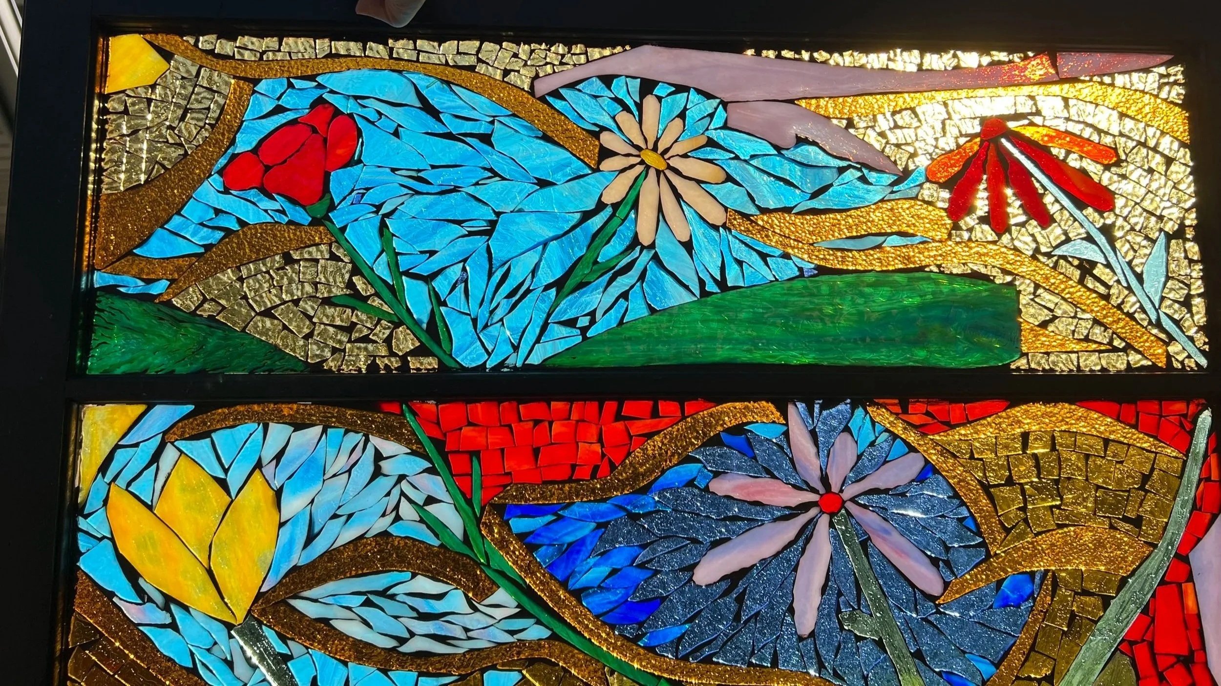 Karen Whalen Original Art | Lake Geneva Art Studio | Colorful stained glass window featuring flowers, leaves, and abstract patterns with gold, green, red, blue, and yellow hues.