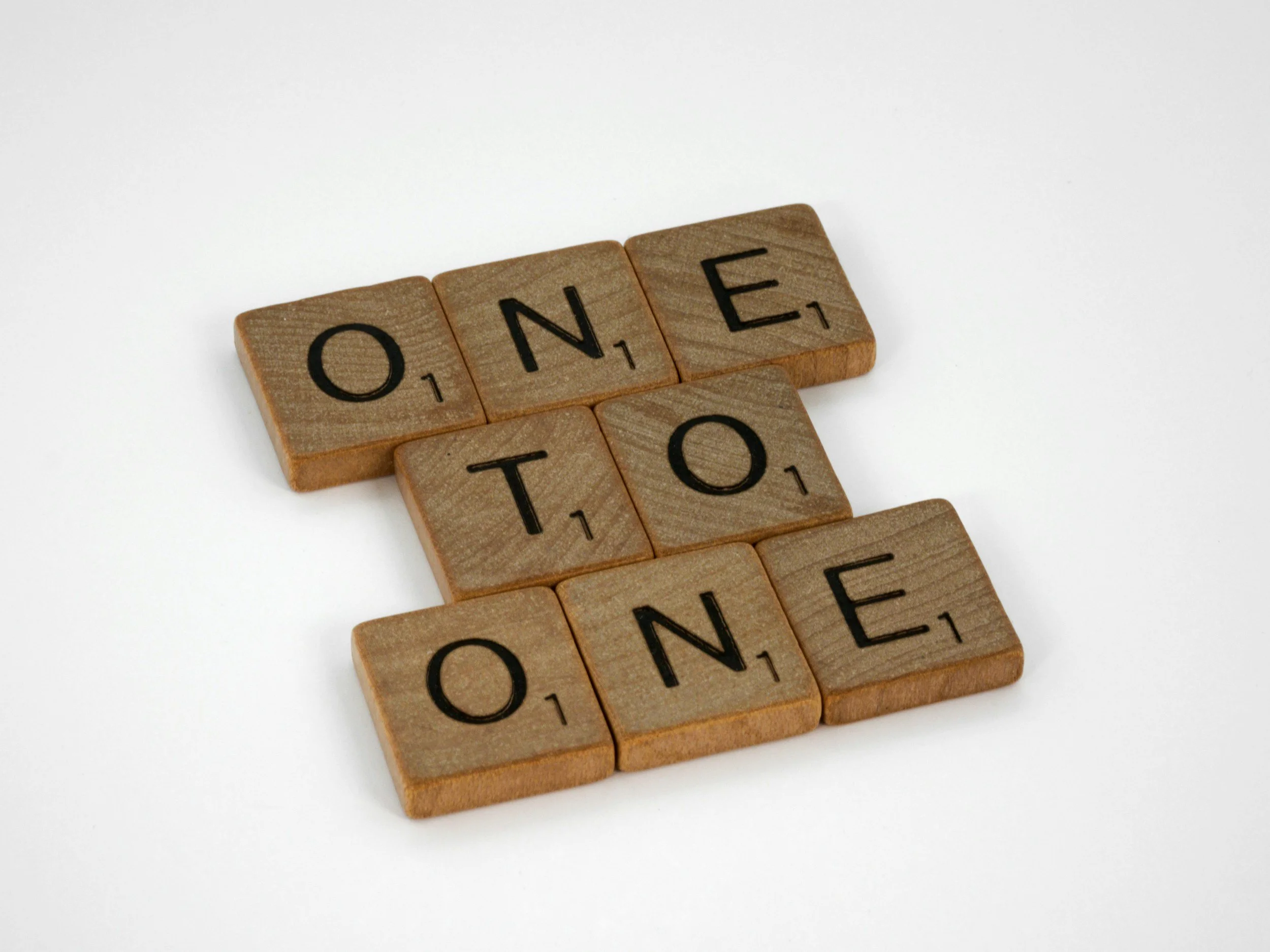 Scrabble tiles arranged to spell the words 'ONE' and 'NOTE' on a white background.
