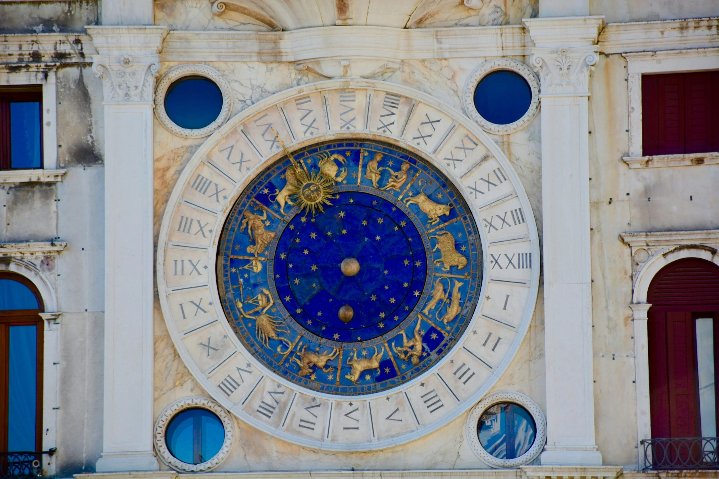 An ancient zodiac wheel, showing the creature symbols for each sign of the zodiac in an inner wheel and a 24 hour clock in the outer wheel.
