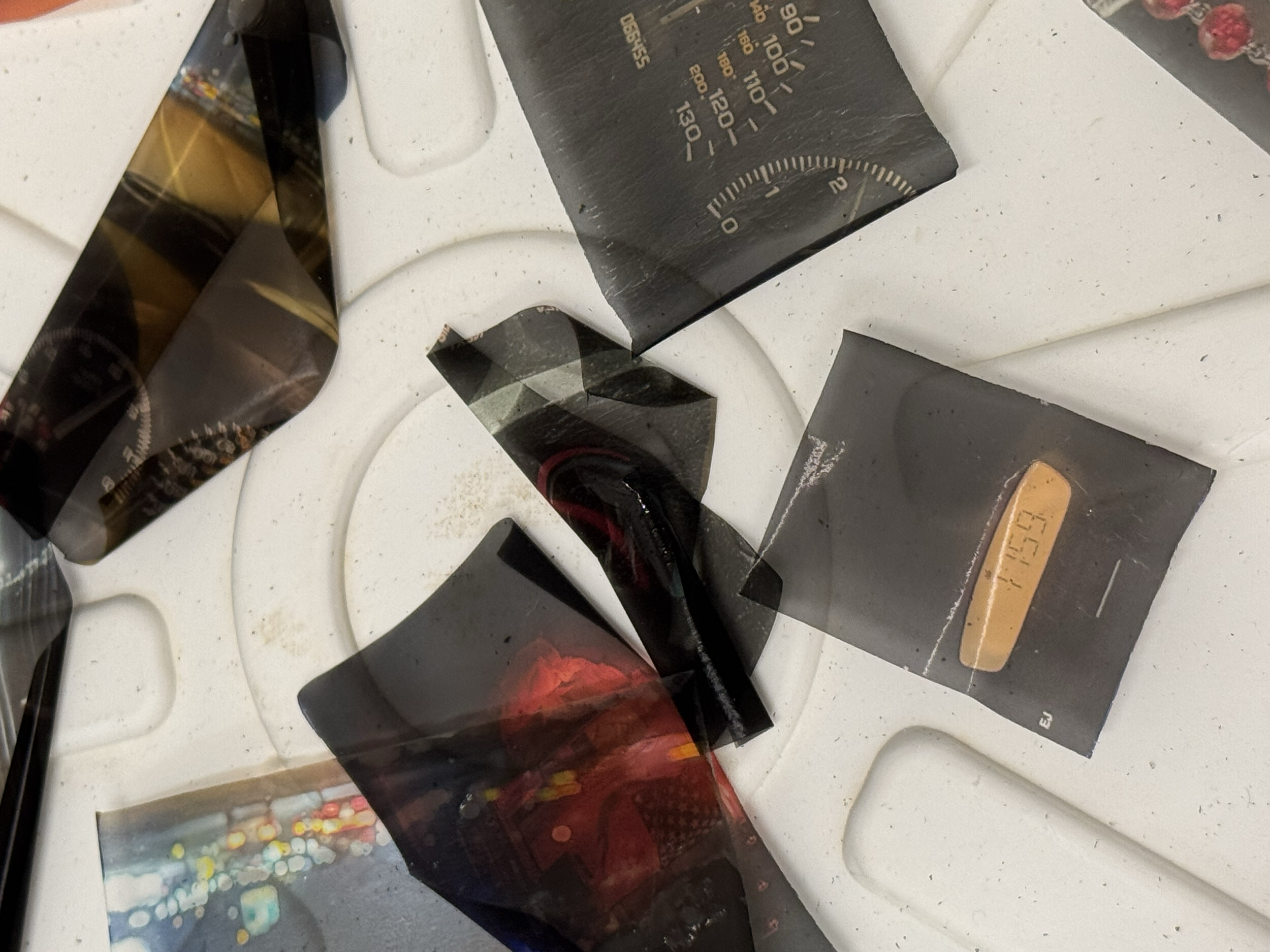 Photographs of various images and objects taped to a white surface, with some parts overlapping.