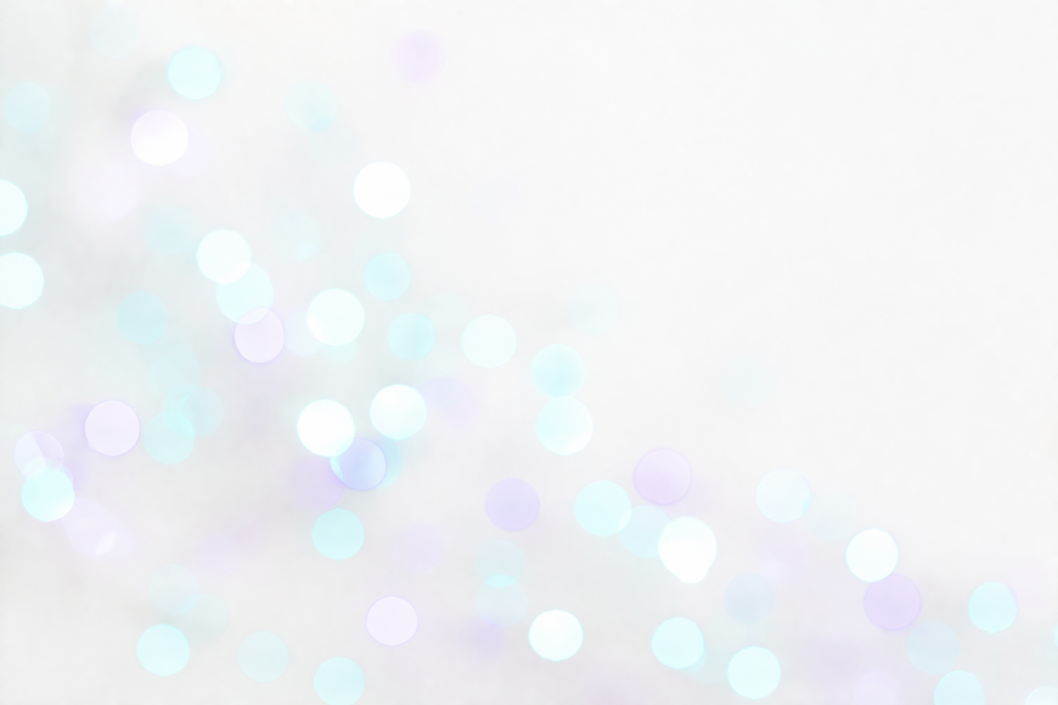 Abstract background with multicolored bokeh light circles on a light, softly blurred backdrop.