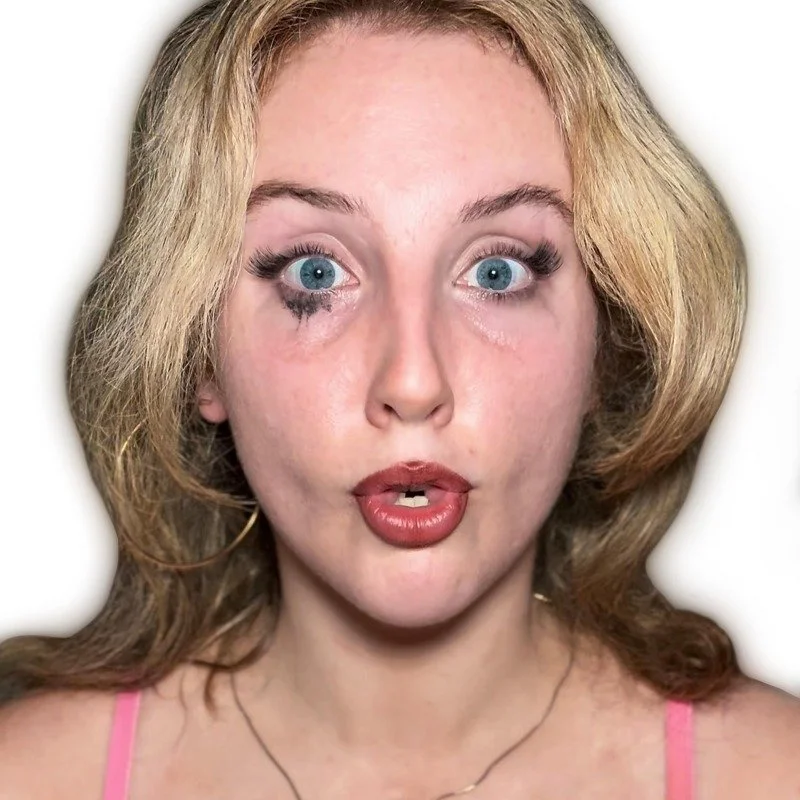 A woman with blonde hair and blue eyes making an exaggerated facial expression.