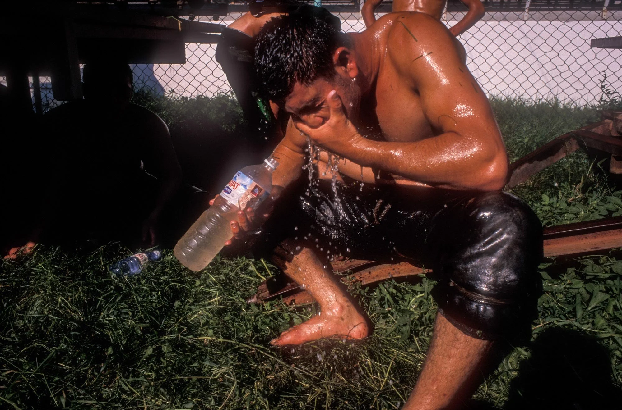 Kirkpinar Olive Oil Wrestling Festival, Edirne, Turkey. An exhausted wrestler / Pehlivan washes the oil from his body at the end of the first day's bouts.