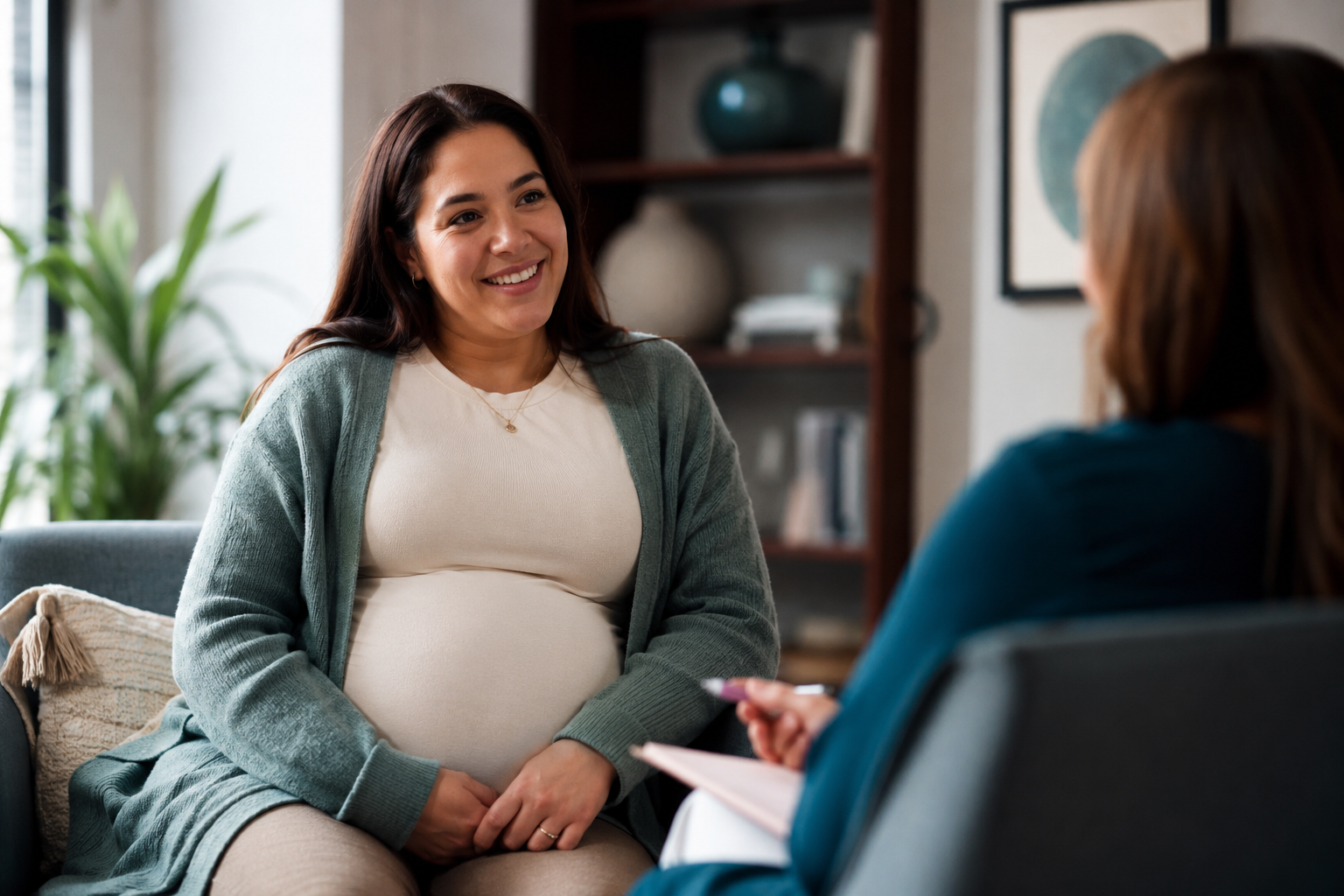 Pregnant woman in conversation with a healthcare provider, representing coordinated perinatal psychiatric care with OB-GYNs and midwives