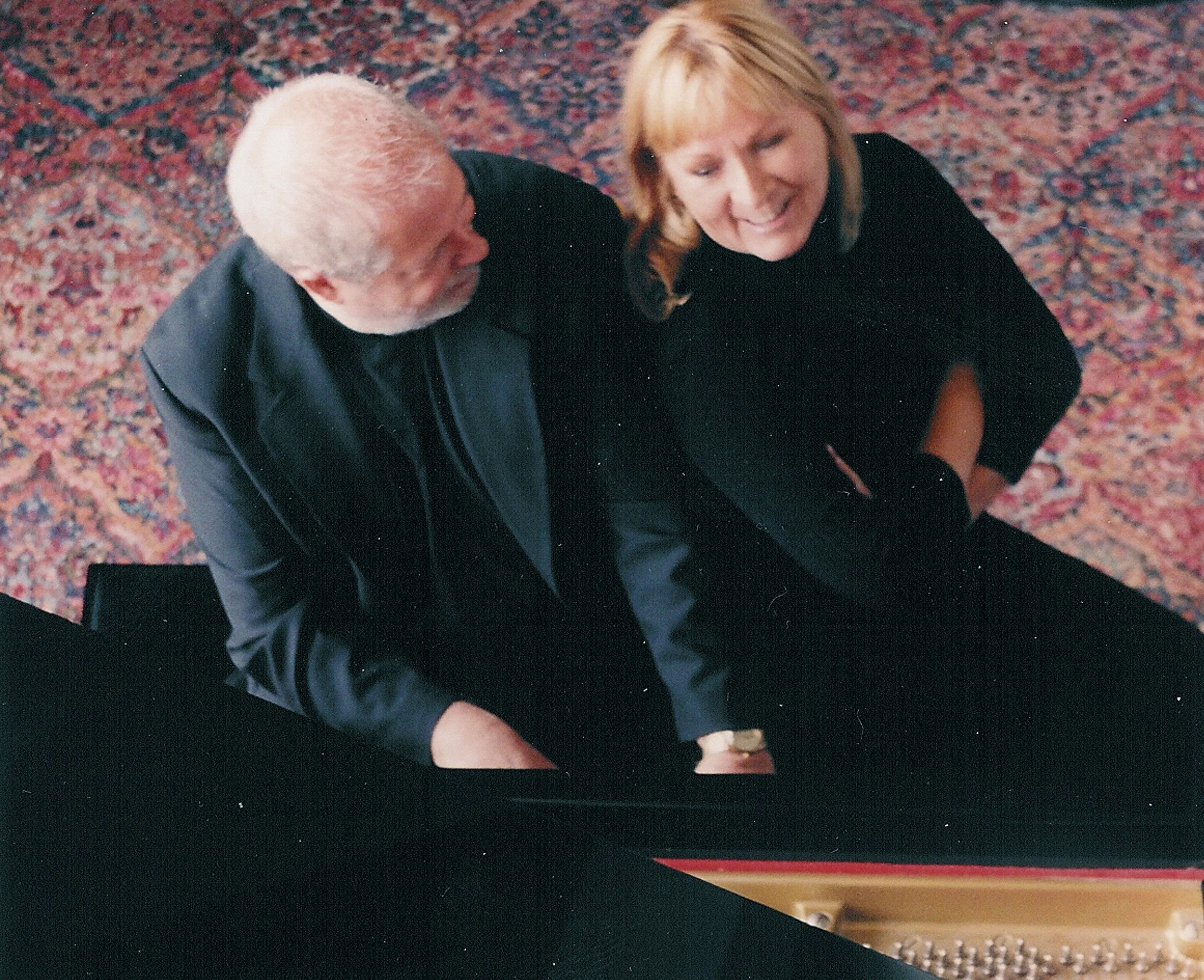 Joani Taylor and Bob Murphy seated at a grand piano.