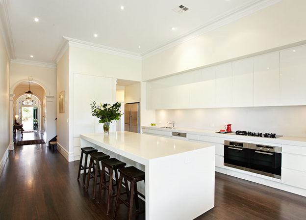 Modern white kitchen with island bench and dark timber floors