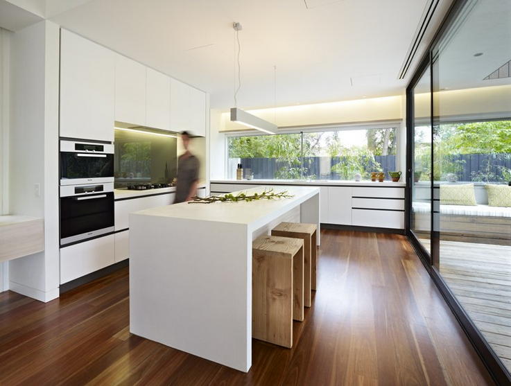 Modern white kitchen with island bench and timber floors