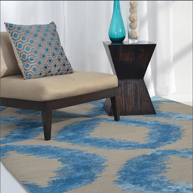 Bold blue patterned rug in living space with matching cushions