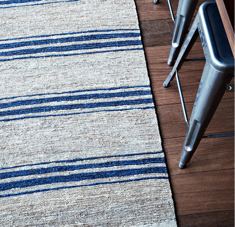 Natural woven rug with blue stripes on timber floor