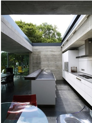 Industrial style kitchen with concrete finishes and a skylight.