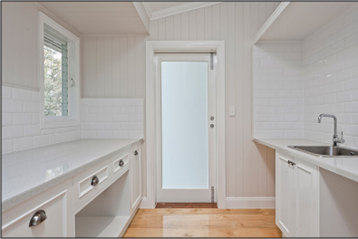 Coastal Style Laundry with White Cabinetry and Timber Floors