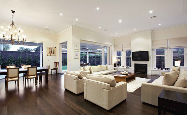 Open plan living and dining room with dark timber floors and natural light