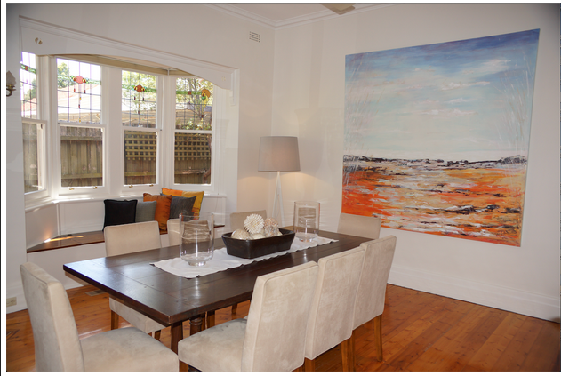 Abstract coastal landscape painting in elegant dining room with bay window