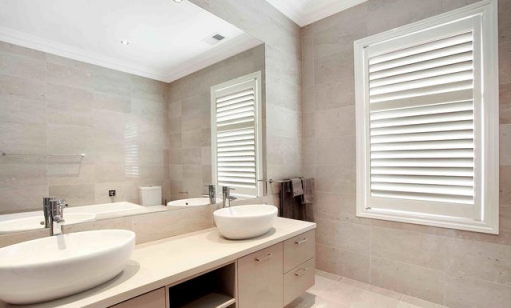 Double basin vanity with matching floor and wall tiles in neutral bathroom