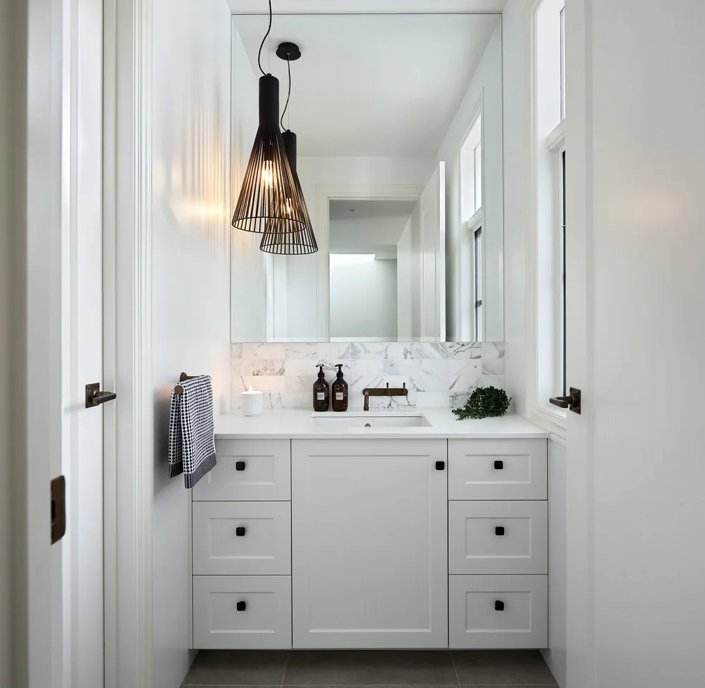 White powder room with shaker style cabinetry marble splashback black pendant light and brass tapware bathroom design Mount Martha Melbourne