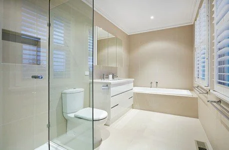 Neutral toned bathroom with built-in bathtub, floating vanity and natural light