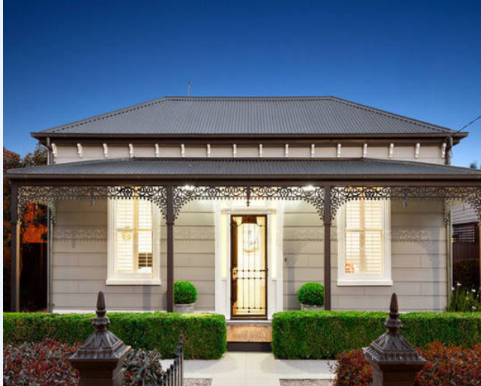 Victorian period home exterior with grey and white colour scheme and lacework verandah