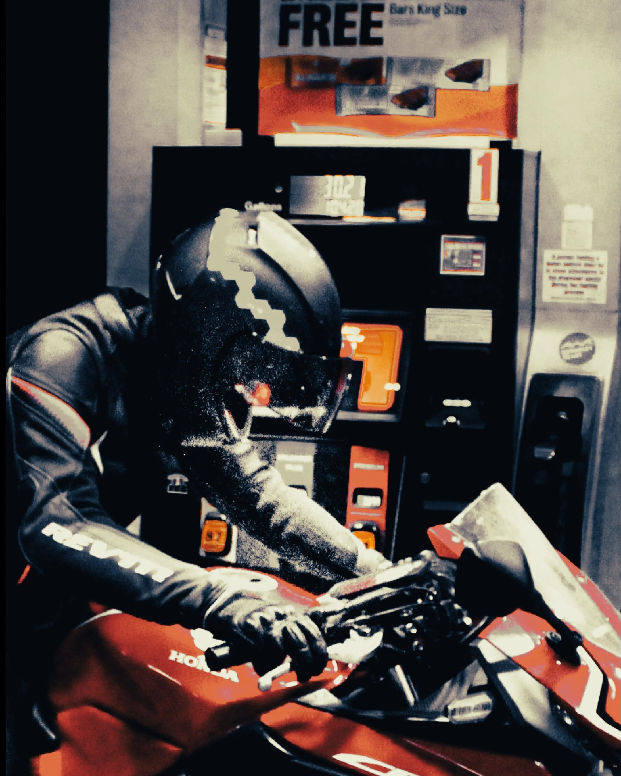 A motorcyclist wearing a black helmet and gloves sitting on a red Honda motorcycle at a vending machine.