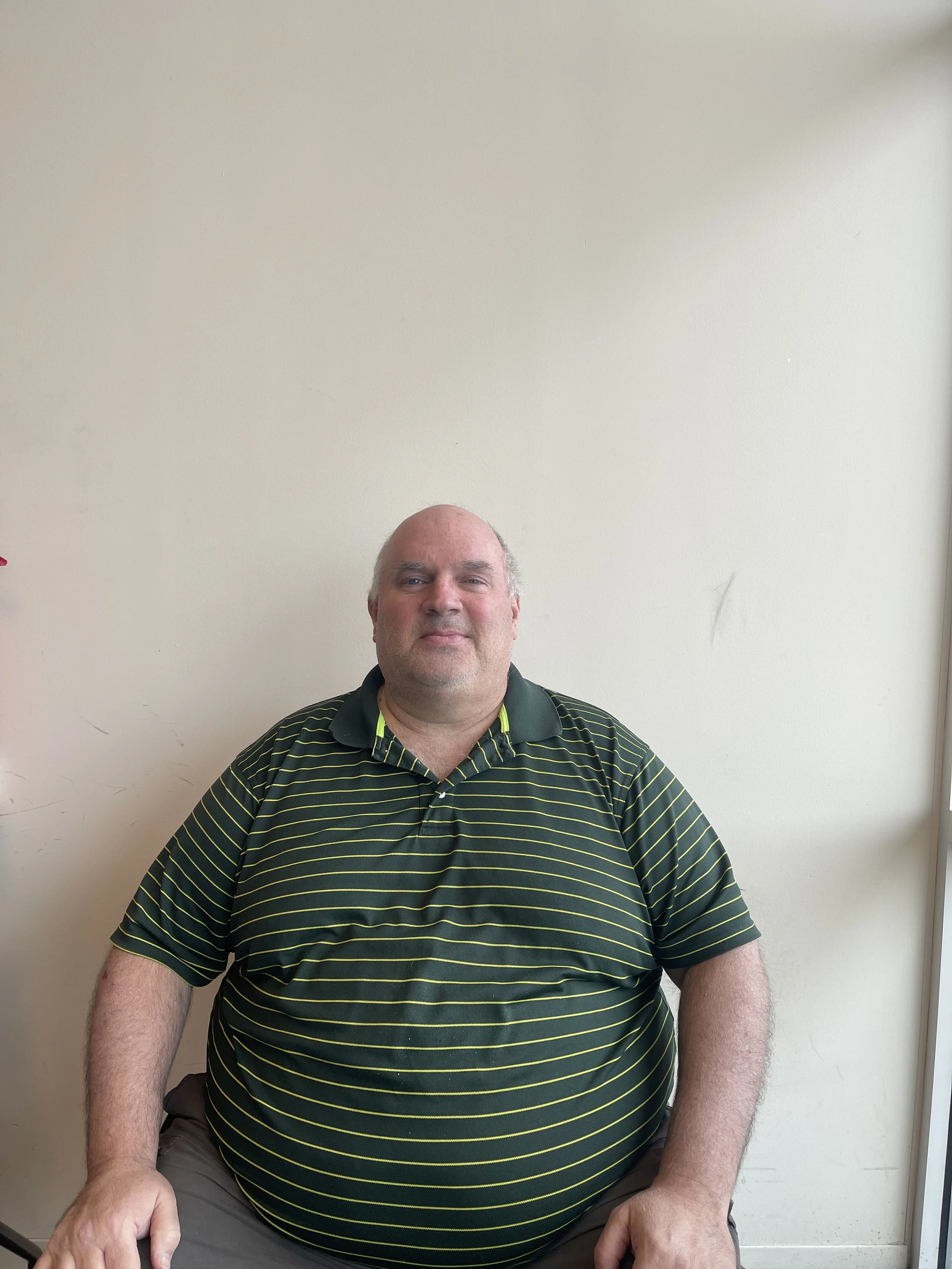 A picture of a man sitting down smiling