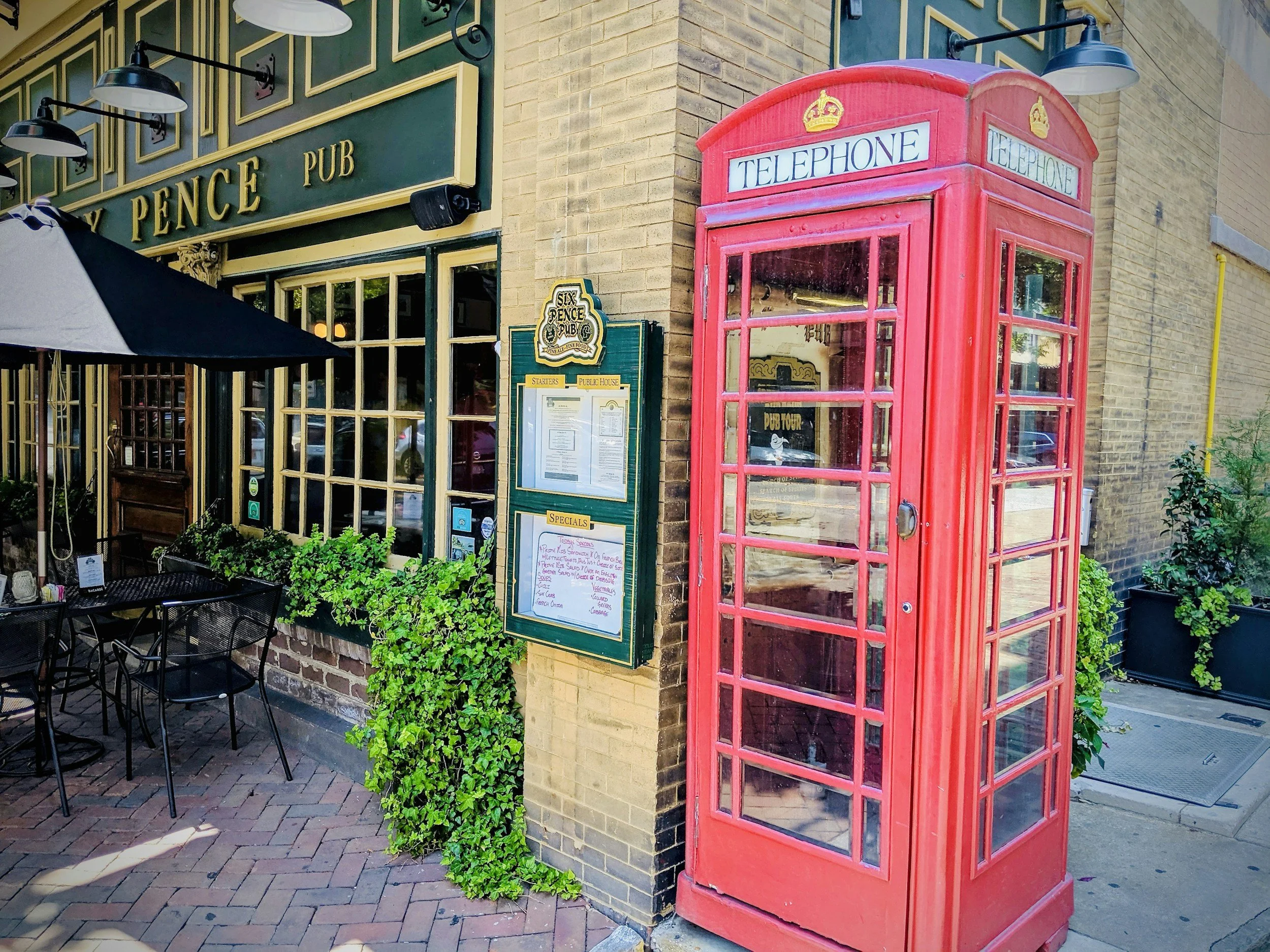 The outside of the Savannah pub, Six Pence, where a red British telephone booth stands.