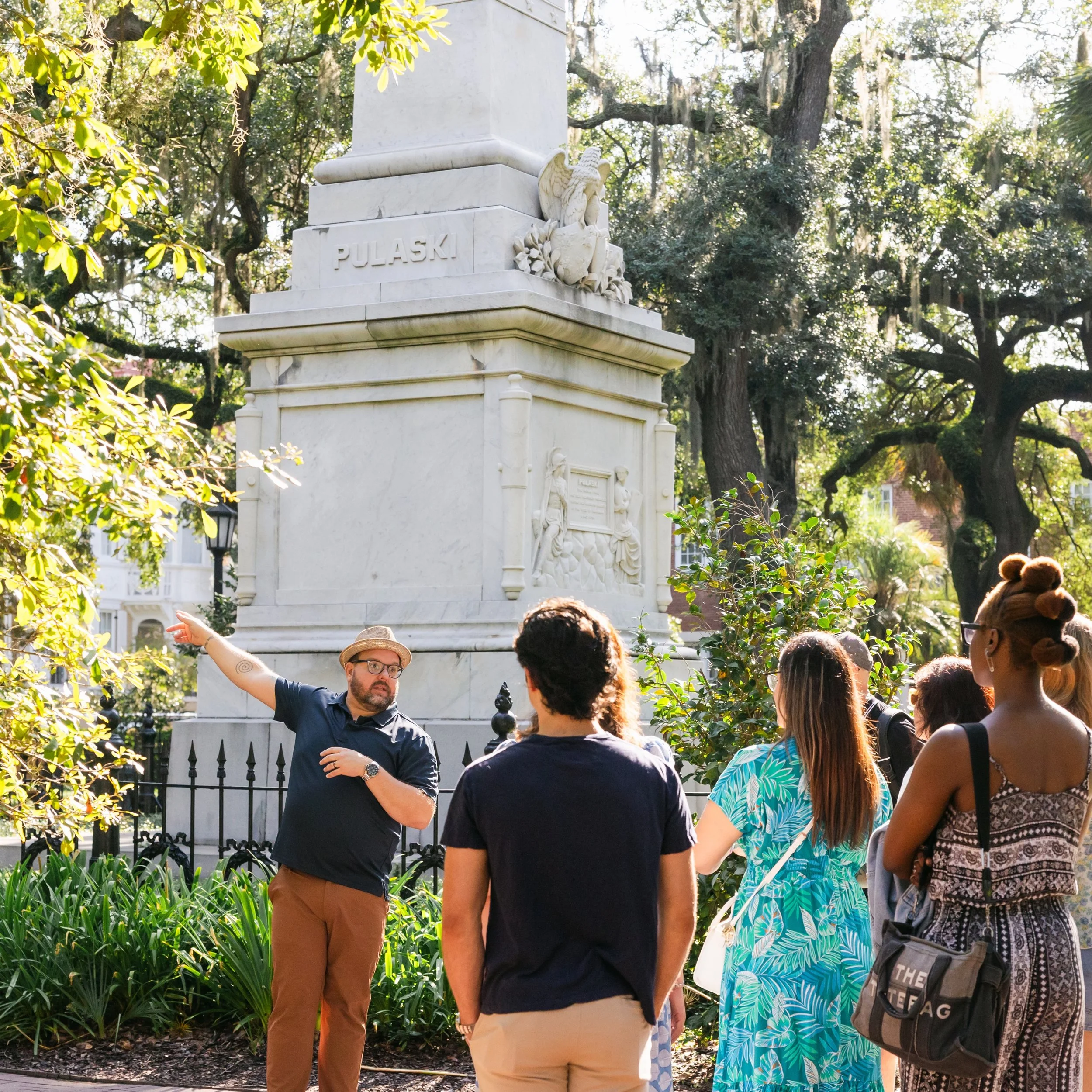 A Savannah Untold tour group in Monterey Square, near the monument to Casimir Pulaski