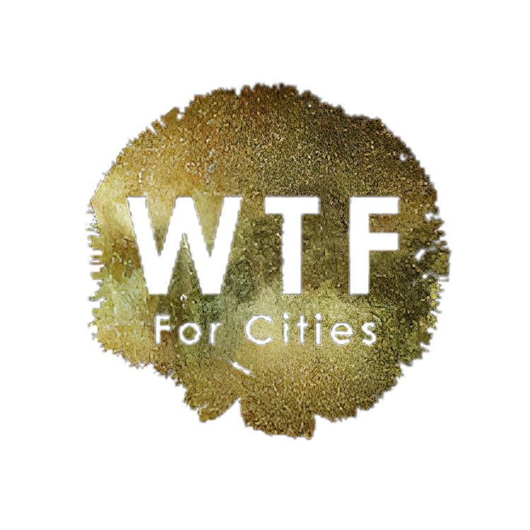 A circular piece of gold with the words 'WTTE For Cities' engraved on it.