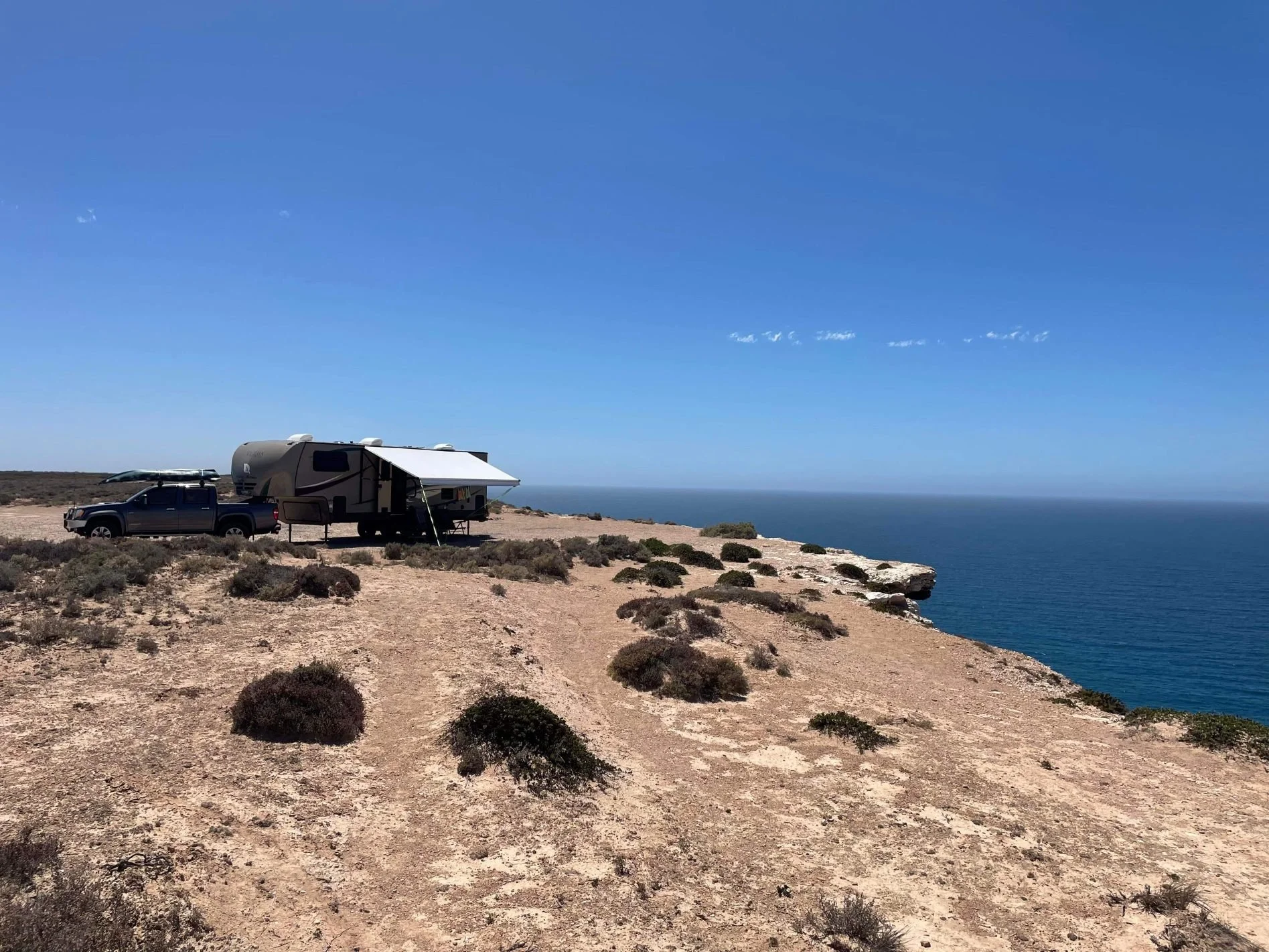 The Tongs for Tossers recreation vehicle (RV) camped up with a campfire and using the fire Tongs for Tossers to safely handle burning wood