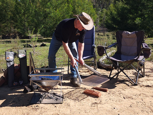 Fire Pit Grill being lifted by Tongs for Tossers Fire Tongs