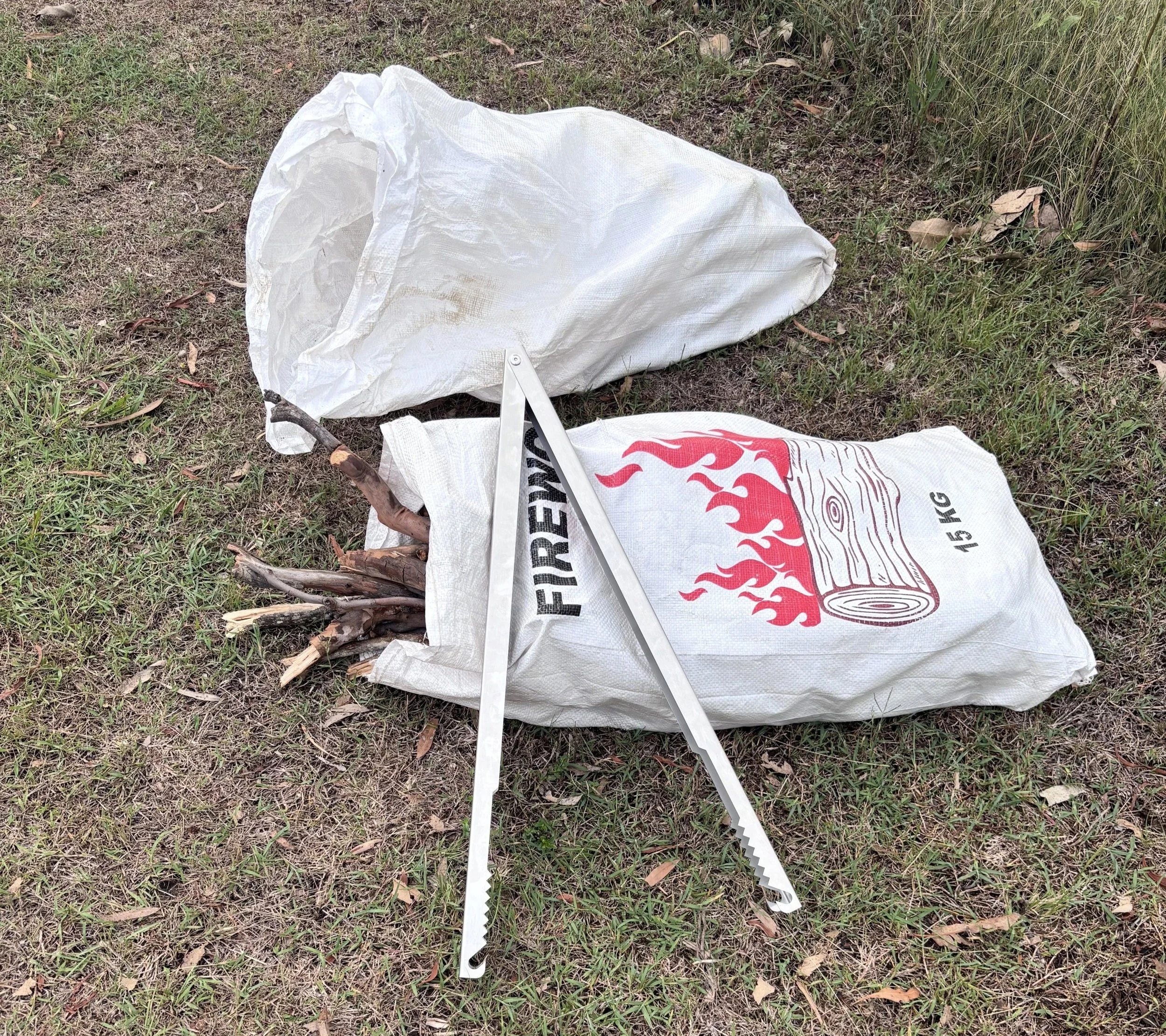 Friends camping with campfire and using Tongs for Tossers Fire Tongs to move hot logs and burning wood
