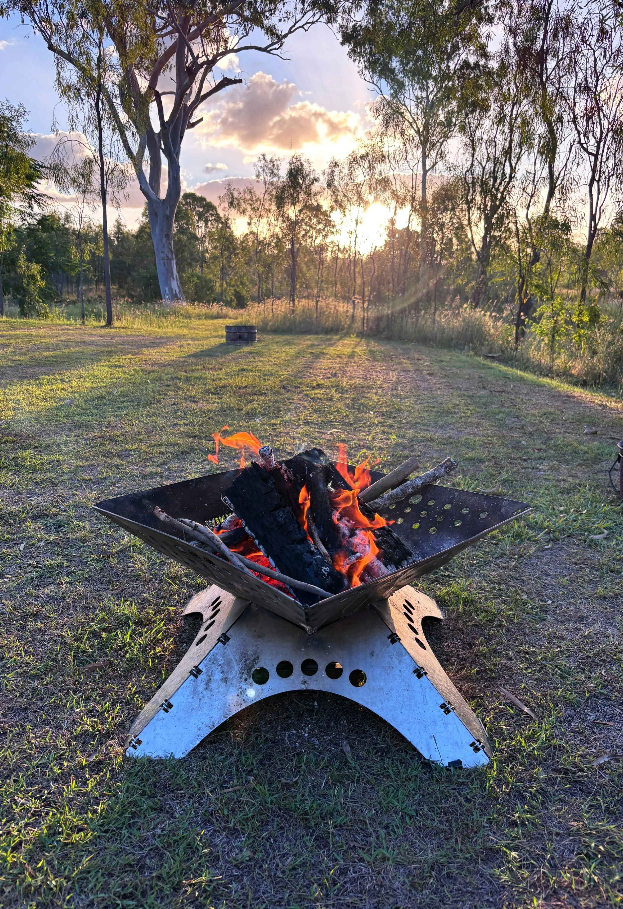 The Tongs for Tossers recreation vehicle (RV) camped up with a campfire and using the fire Tongs for Tossers to safely handle burning wood