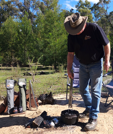 Tongs for Tossers lifting Camp Oven out of Camp Fire