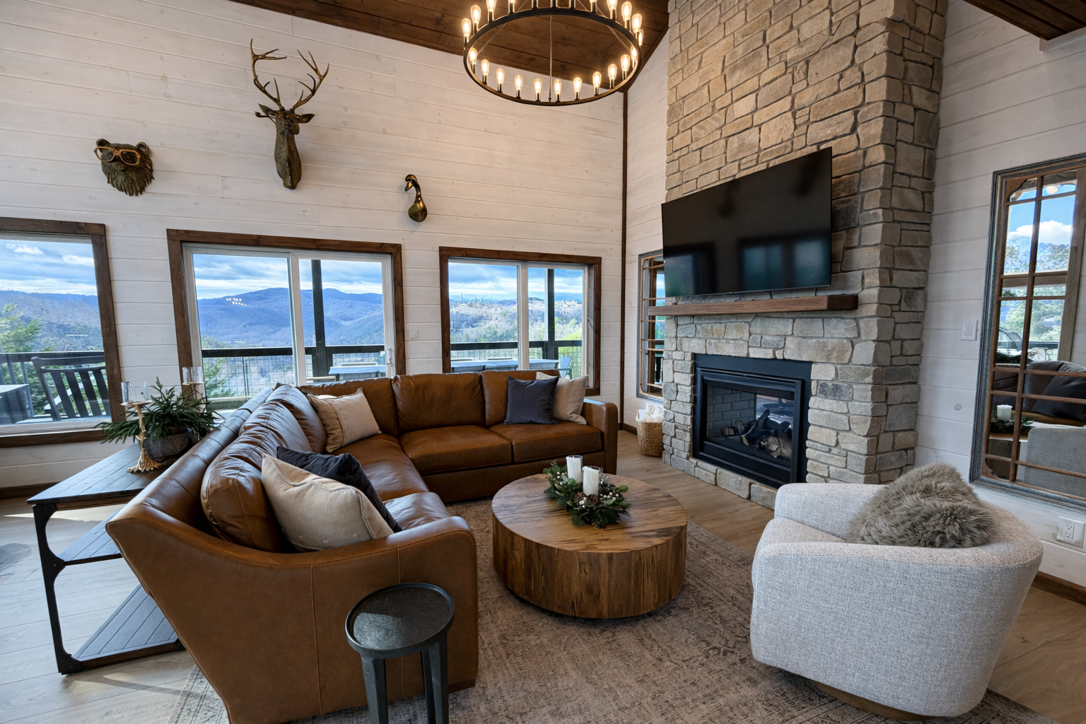 Mountain cabin living room in Gatlinburg, TN featuring a stone fireplace, warm wood finishes, and contemporary furniture.
