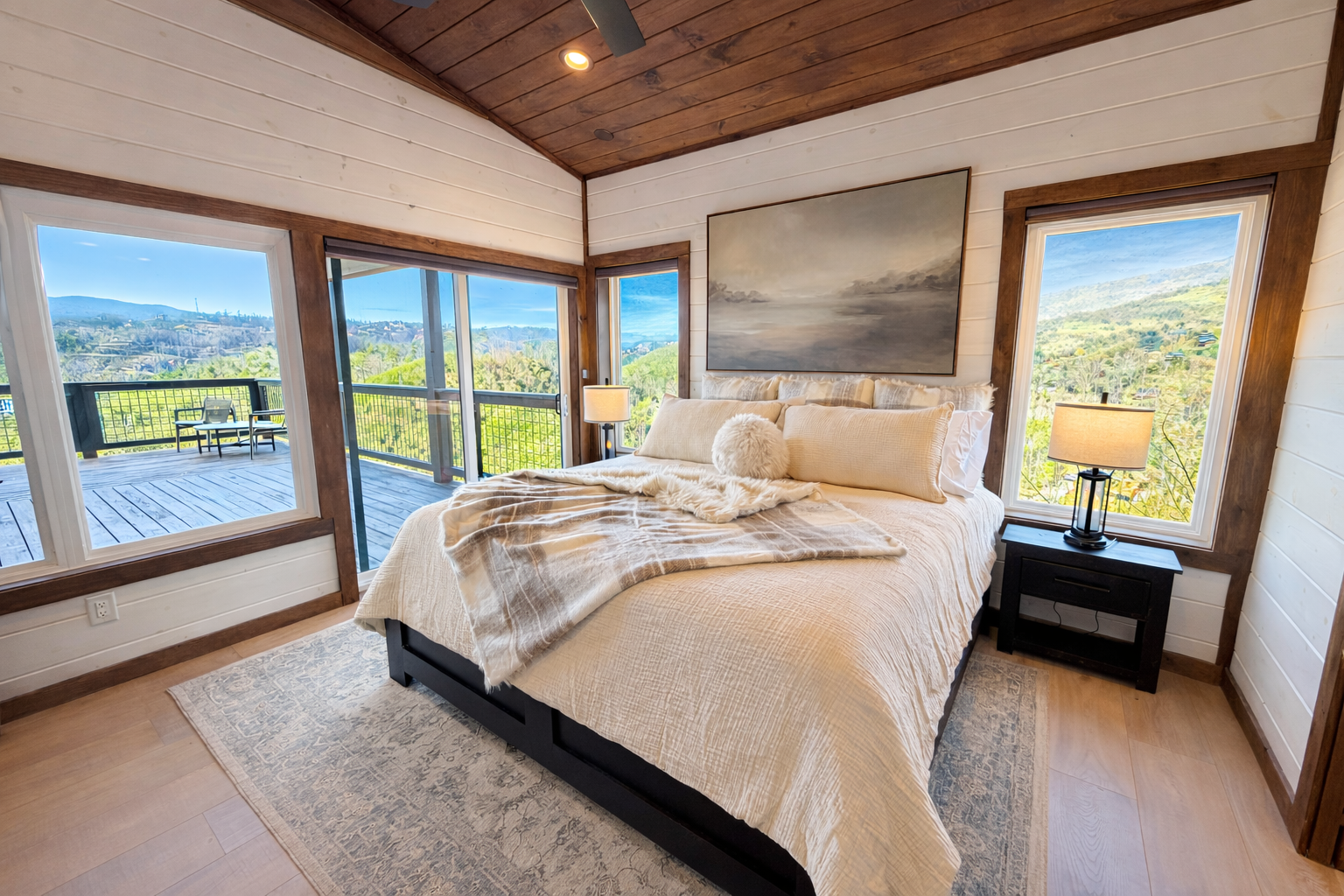 Bedroom with large windows and mountain views in a Smoky Mountain cabin
