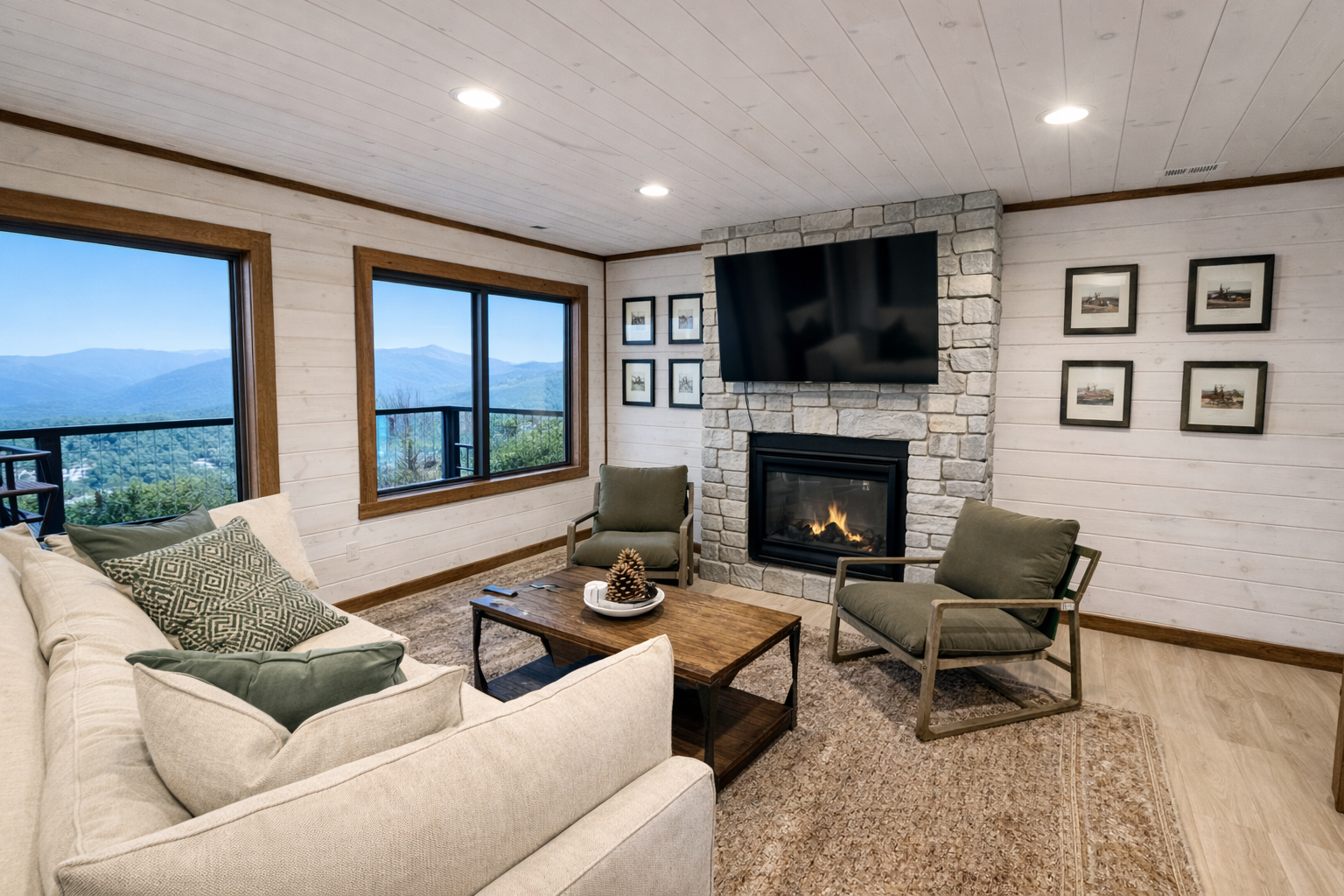 Comfortable Gatlinburg cabin living room featuring a fireplace, modern seating, and framed mountain scenery.