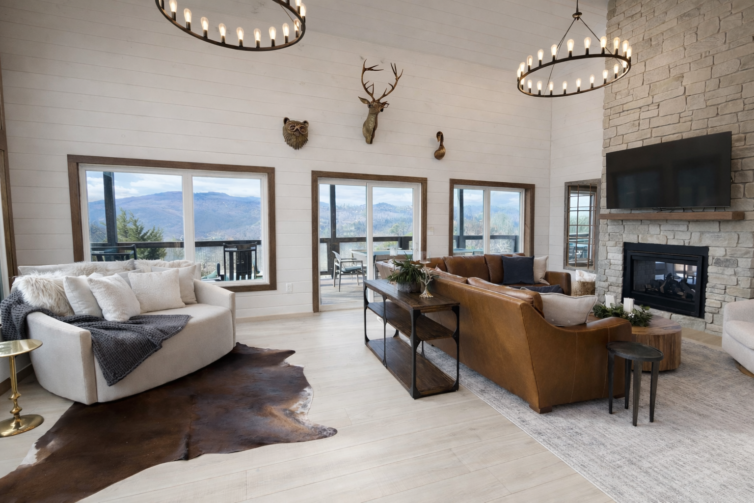 Open-concept living room with vaulted ceilings, large windows, and modern mountain design in a Gatlinburg cabin.