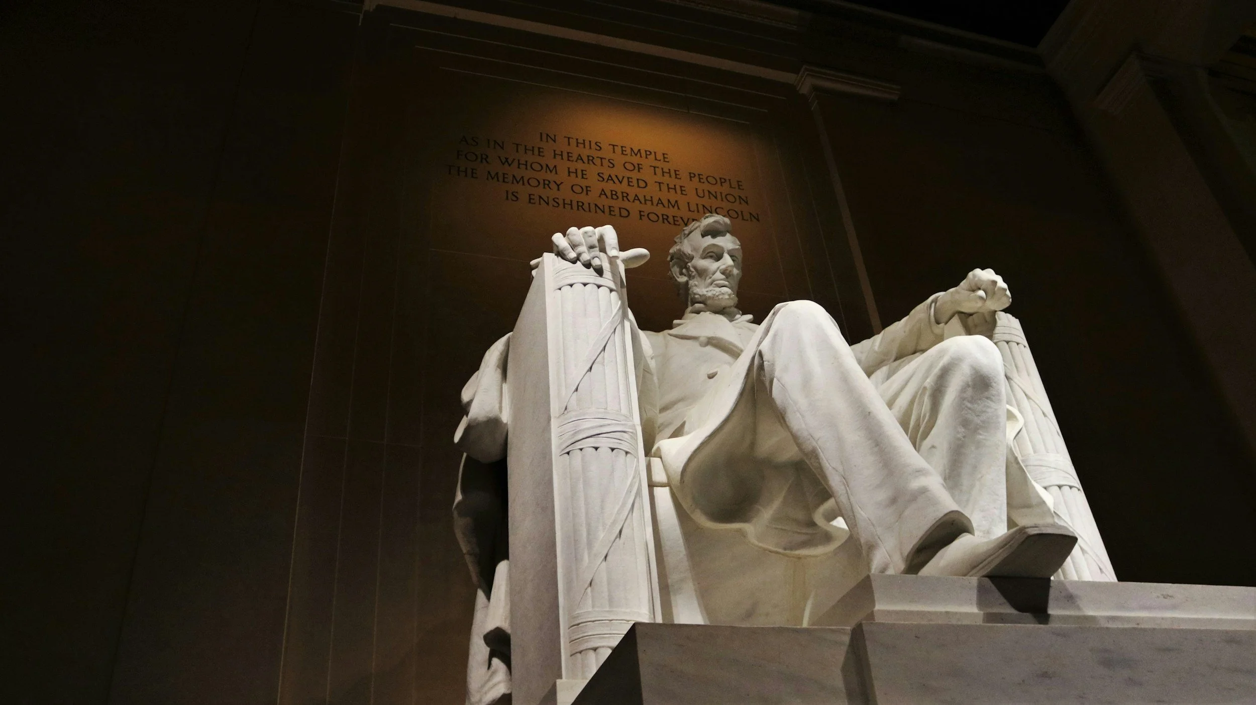 Close-up view of the statue of Abraham Lincoln in front of a wall with an inscription at the Lincoln Memorial in Washington, D.C.