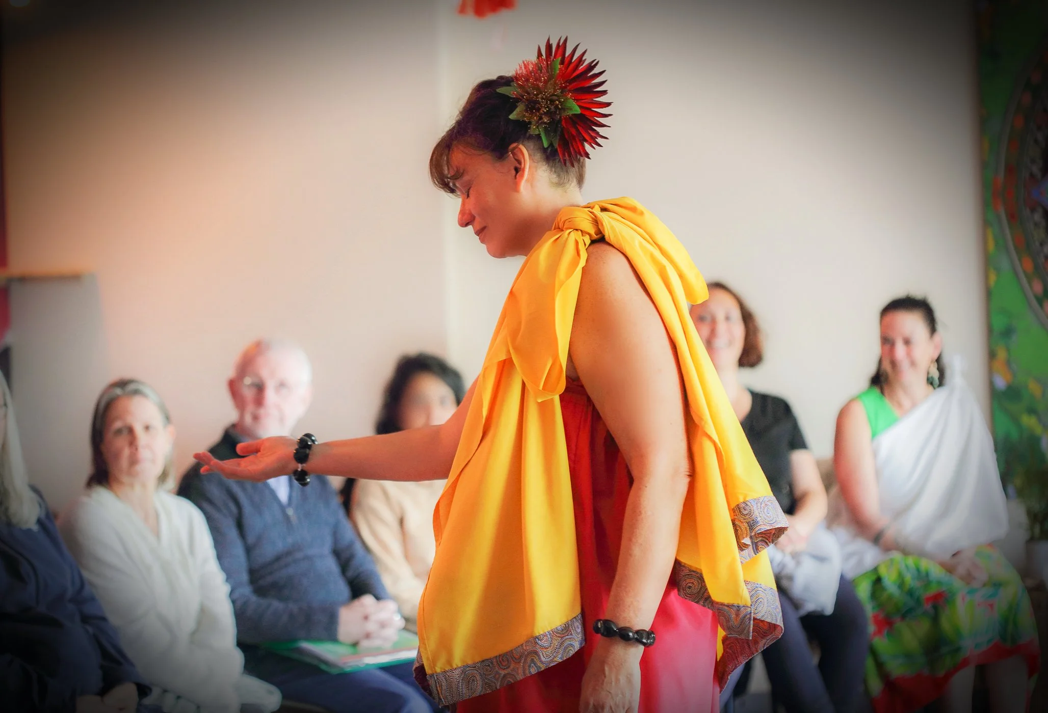 Kumu Paʻa Julia Nālani in traditiional Hawaiian dress teaching Hawaiian Healing