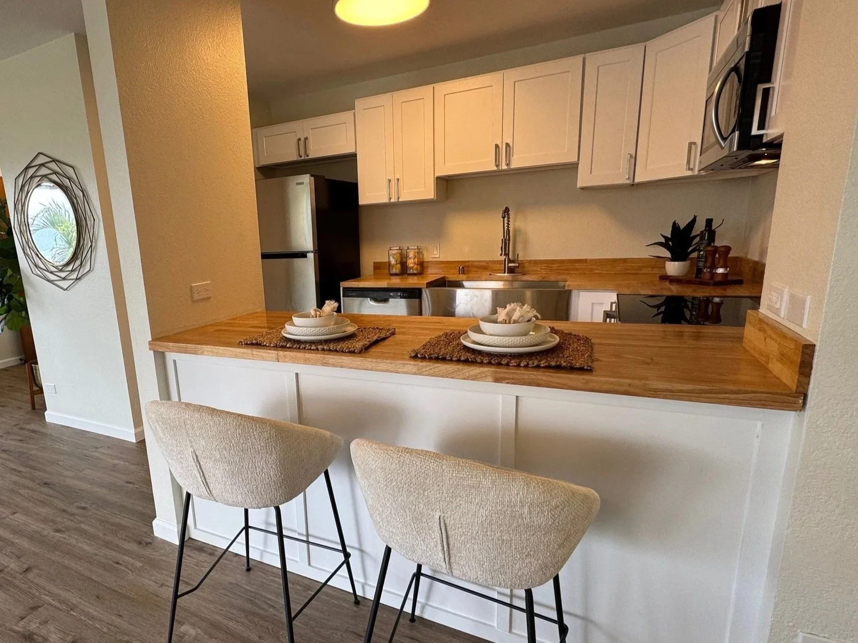 Modern Kaneohe kitchen renovation with white cabinets and wood countertops.