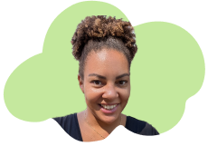 Portrait of a young woman with curly hair smiling, against a green background.