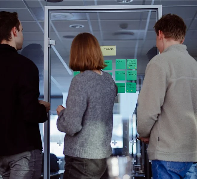 tre personer som gjør note and vote i en workshop